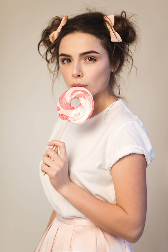 Красива брюнетка дівчина з цукерками в руках
 - Фото, зображення