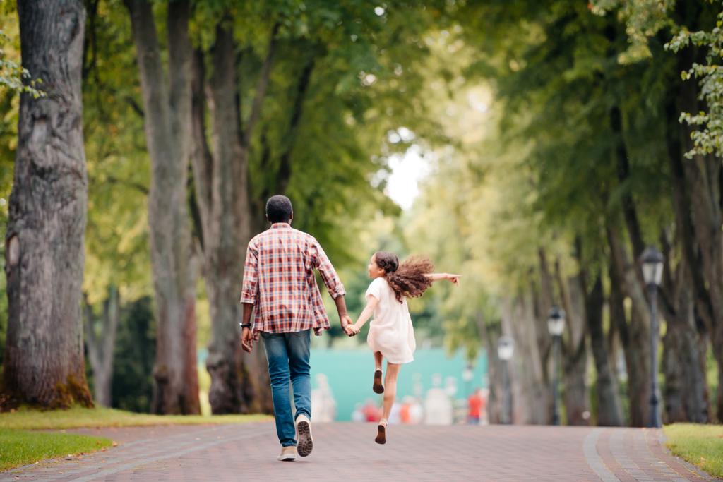 Mädchen läuft mit Großvater im Park  - Foto, Bild
