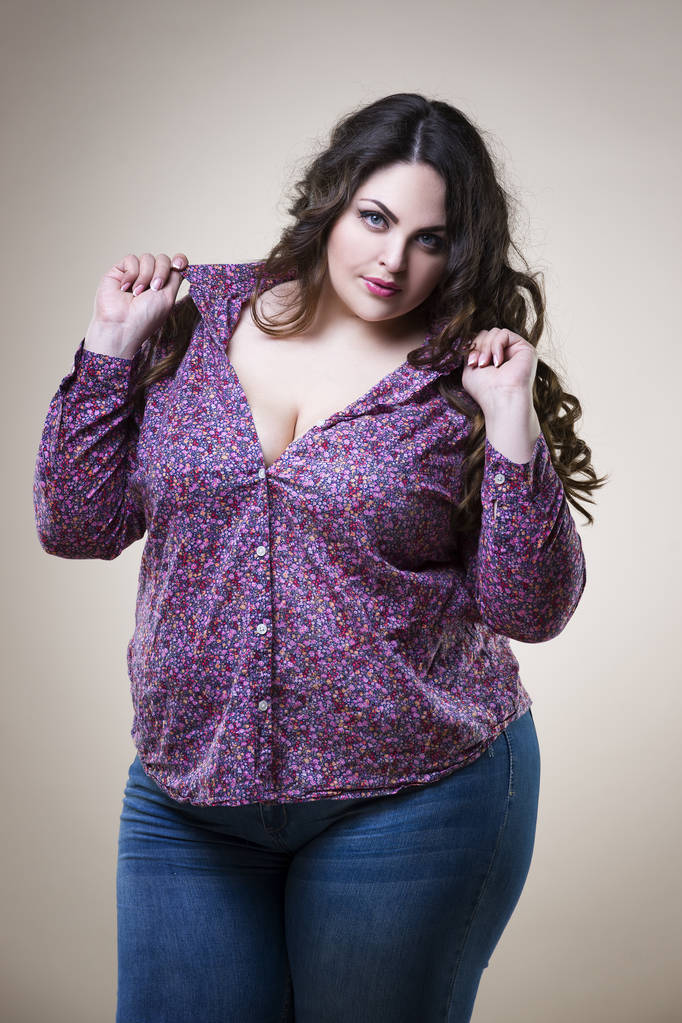 Modelo de moda de talla grande en ropa casual, mujer gorda sobre fondo beige de estudio, cuerpo femenino con sobrepeso - Foto, imagen