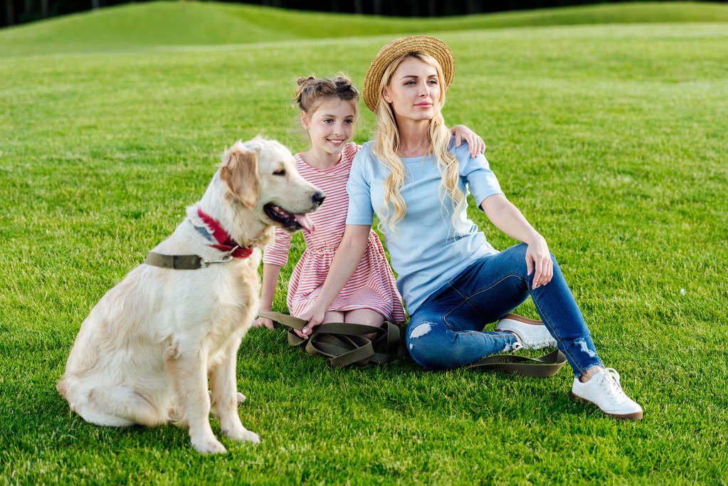 moeder en dochter met hond in park - Foto, afbeelding