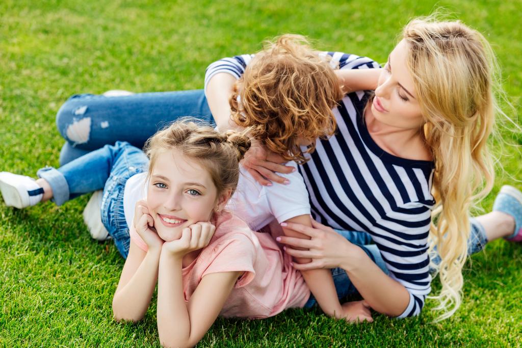 mère avec des enfants reposant sur l'herbe
 - Photo, image
