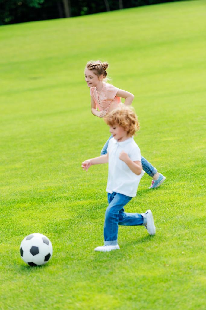 siblings playing soccer in park - Photo, Image