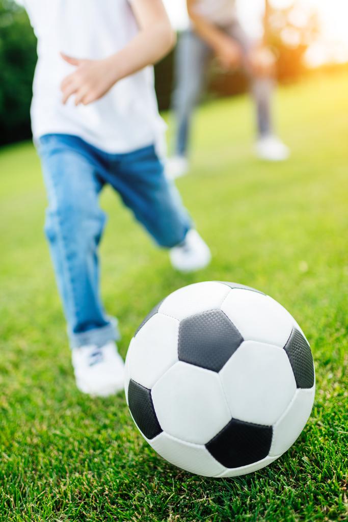 jongen te voetballen in park - Foto, afbeelding