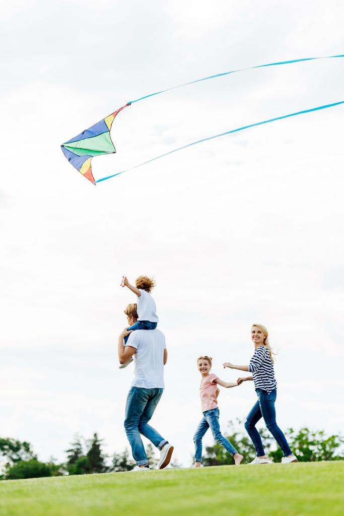 familia jugando con cometa en el parque
 - Foto, Imagen