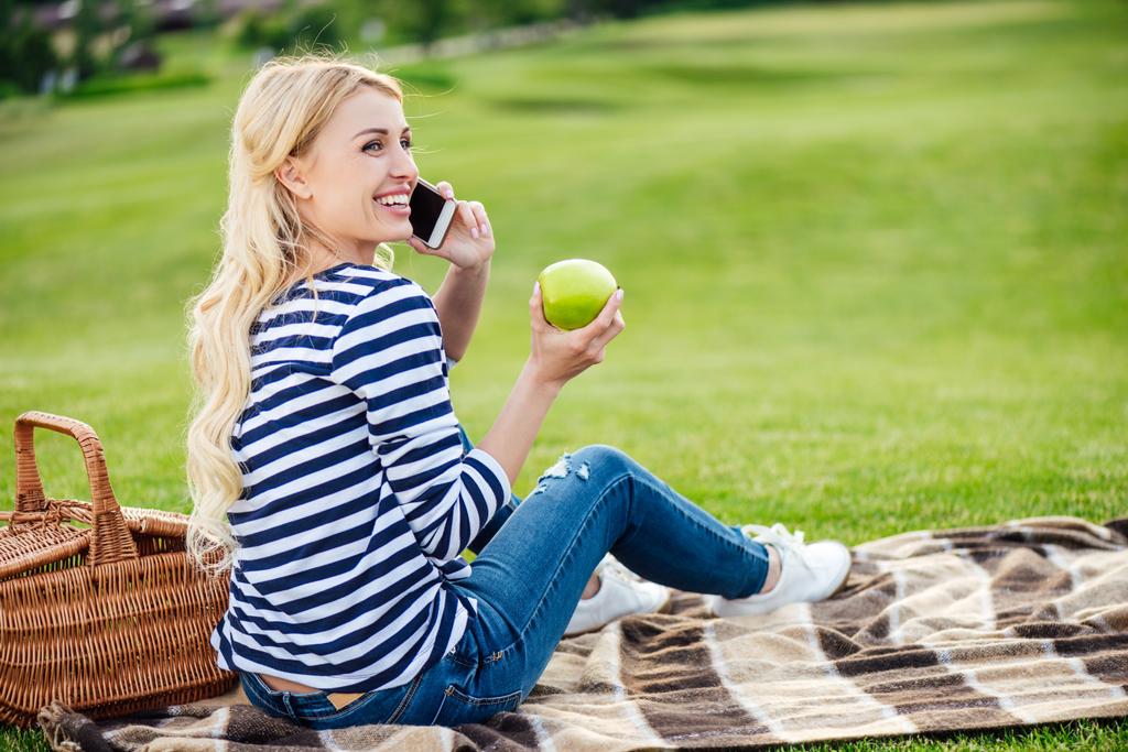 vrouw praten over smartphone op picnic - Foto, afbeelding