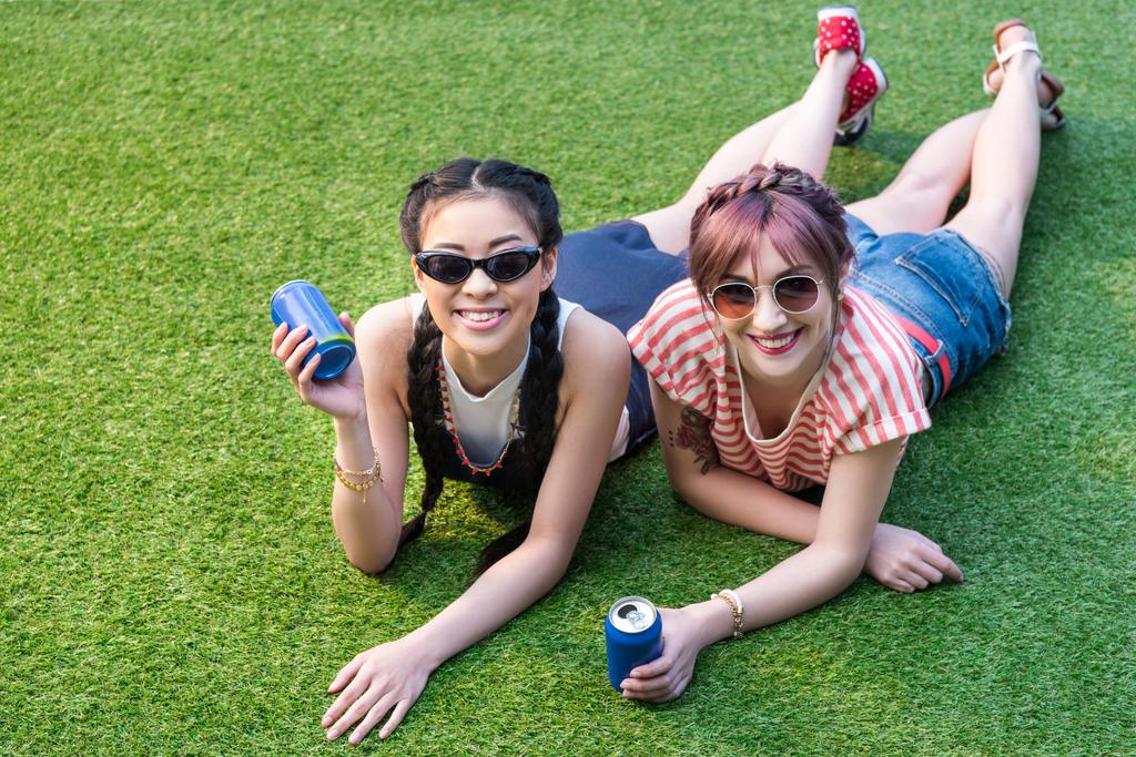 meninas multiétnicas com latas de refrigerante
 - Foto, Imagem