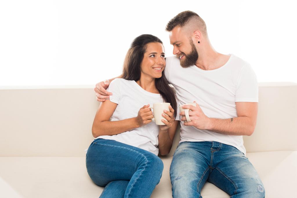attraktives Paar auf Couch mit Kaffee - Foto, Bild