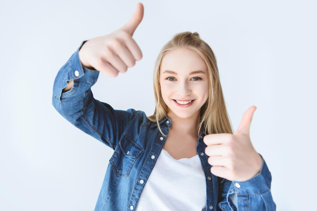 Sonriente adolescente chica mostrando pulgares hacia arriba
 - Foto, Imagen