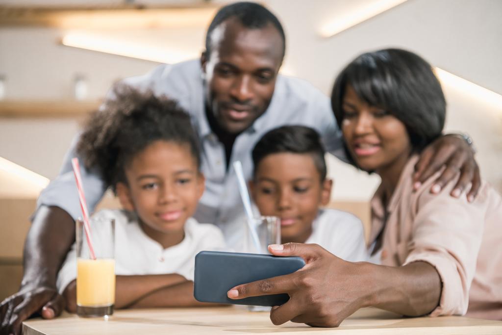 familia afroamericana mirando el teléfono
 - Foto, imagen