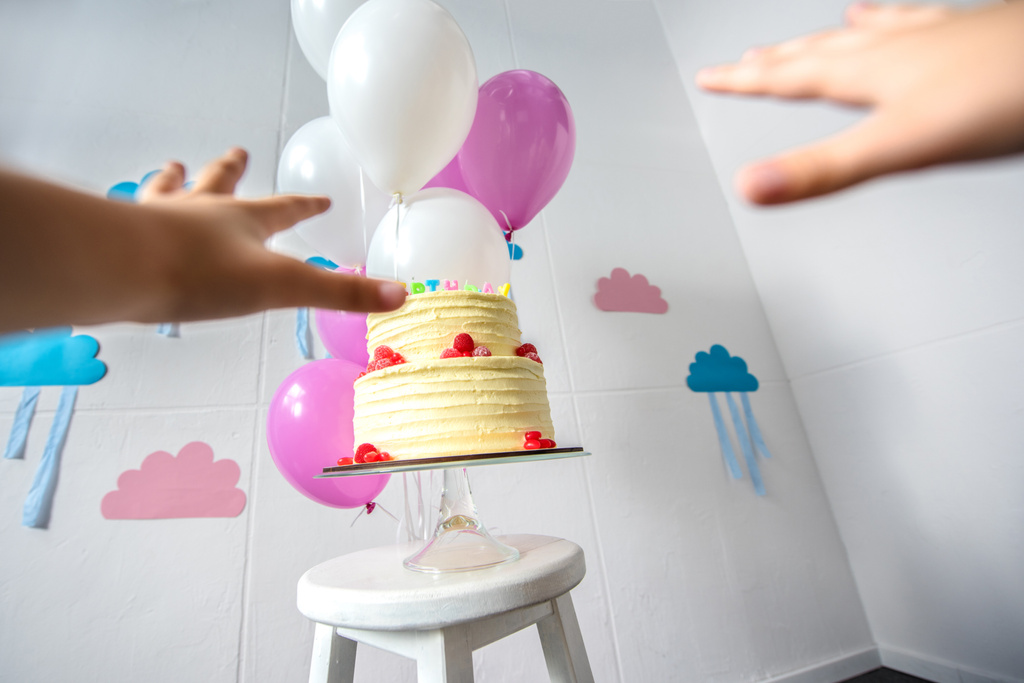 誕生日ケーキに手を差し伸べる手 - 写真・画像