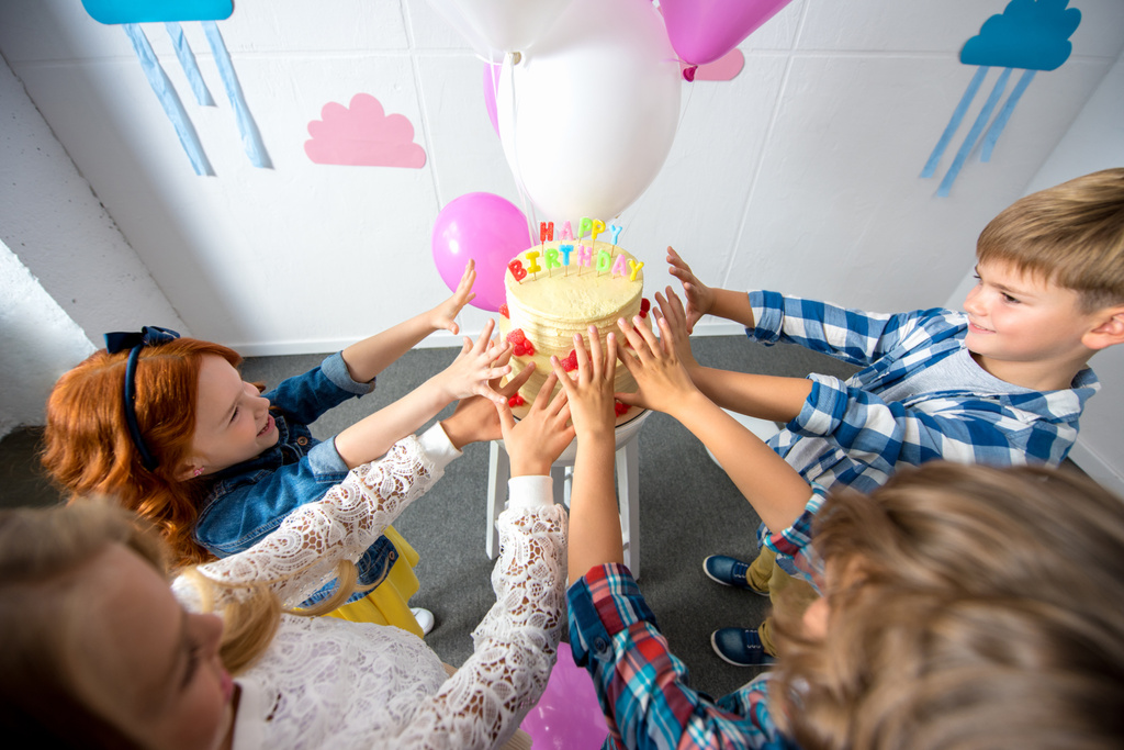 kids reaching to birthday cake - Photo, Image