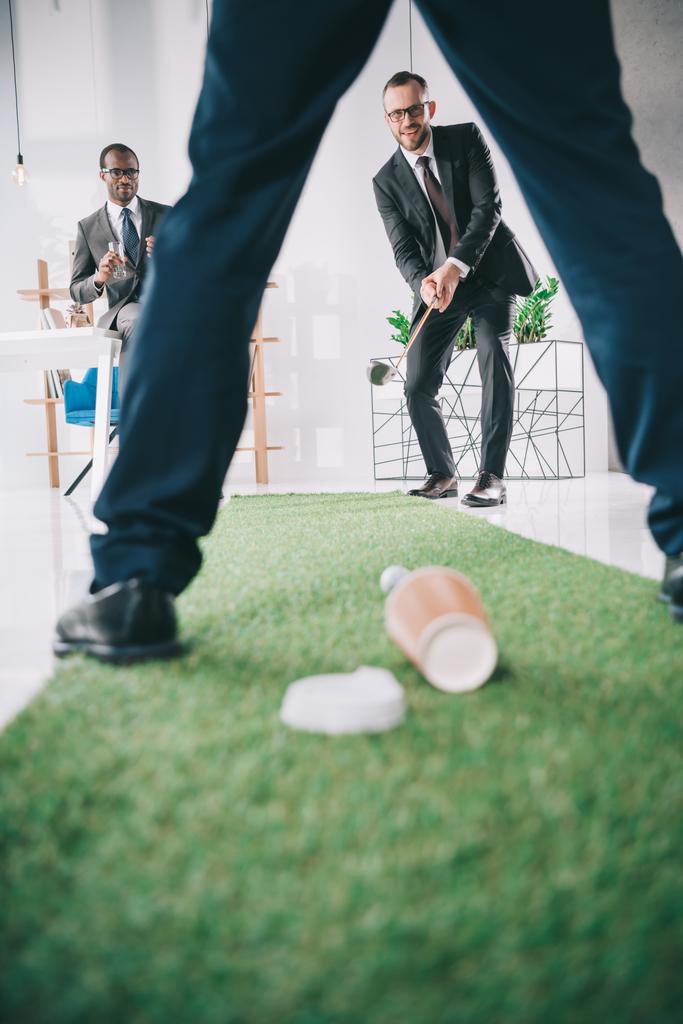 бизнесмены играют в мини-гольф
 - Фото, изображение