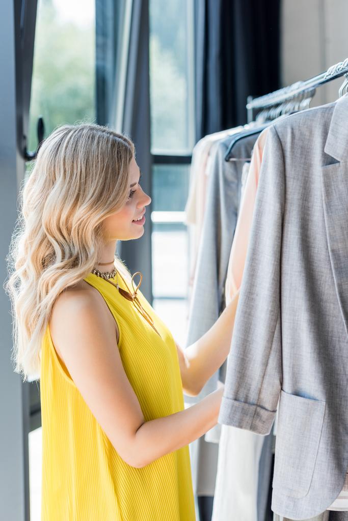 Жінка вибирає одяг в магазині
 - Фото, зображення