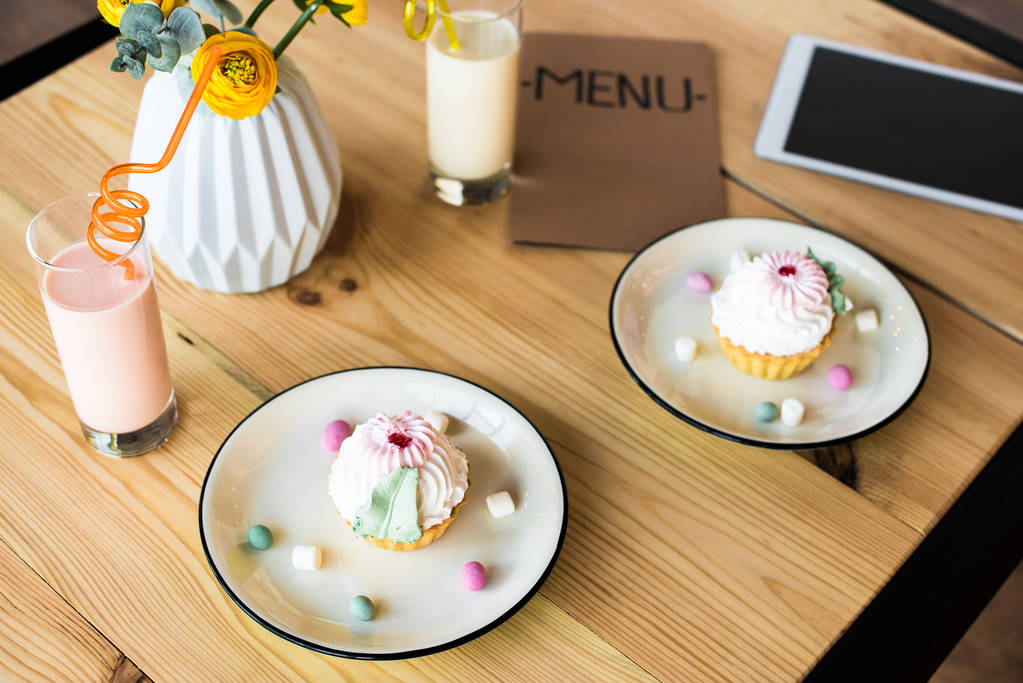 Milchshakes und Cupcakes auf dem Tisch - Foto, Bild