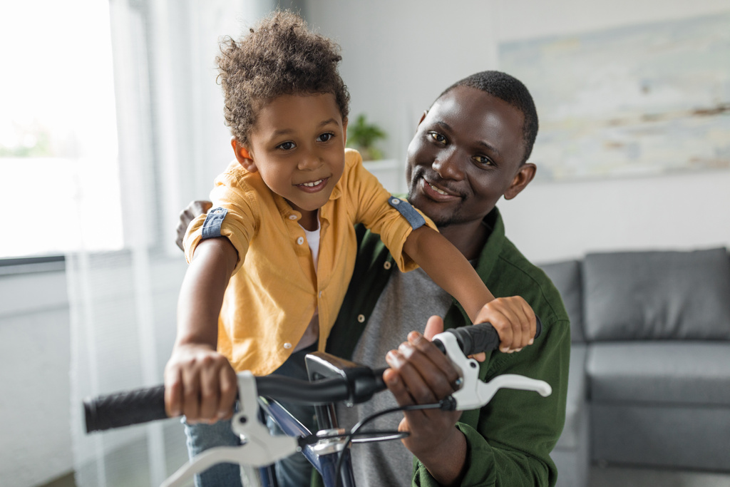 isä ja poika leikkivät polkupyörällä kotona
 - Valokuva, kuva