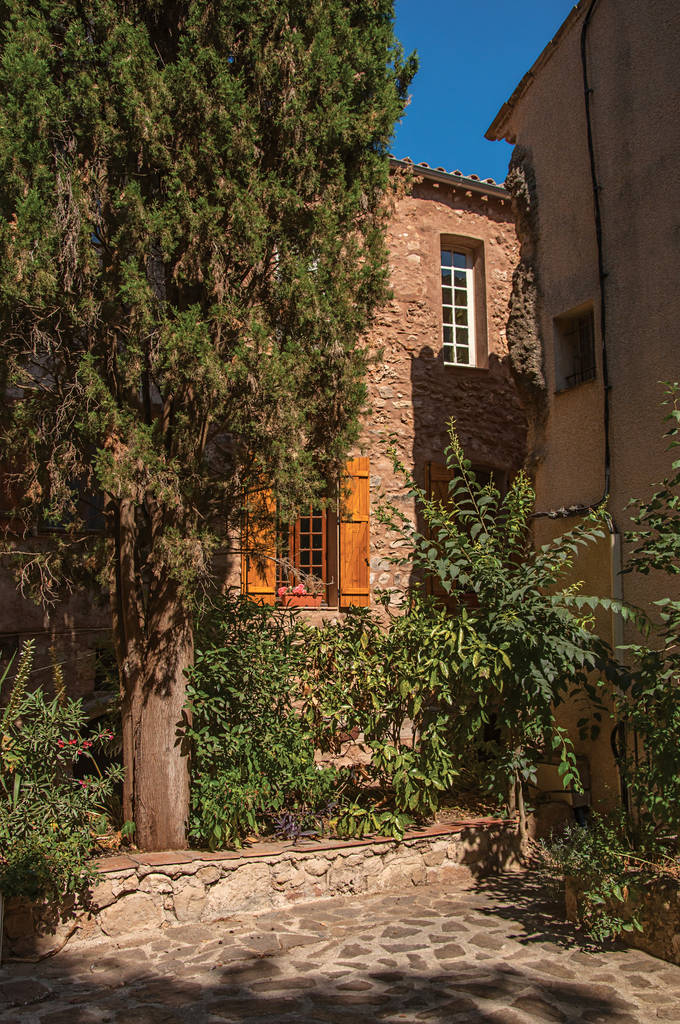 Widok na kamienne domy w wąską uliczkę, w Les Arcs-sur-Argens. - Zdjęcie, obraz