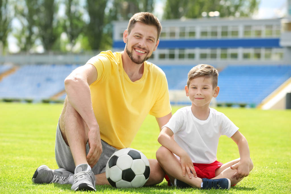 Dad and son with soccer ball in stadium - Photo, Image