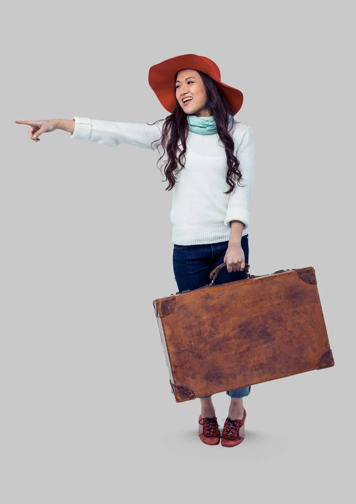 γυναίκα που κρατά βαλίτσα με γκρίζο φόντο - Φωτογραφία, εικόνα