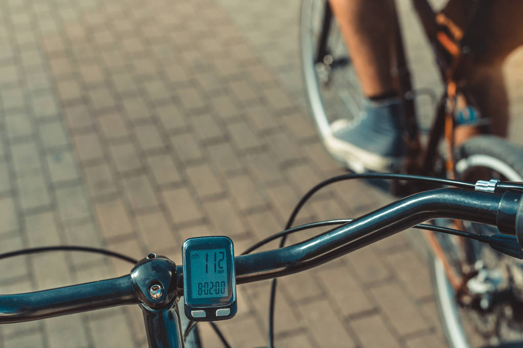 Cuentakilómetros de la computadora de la bicicleta en el volante en el fondo del ciclista, punto de vista tiro
 - Foto, Imagen