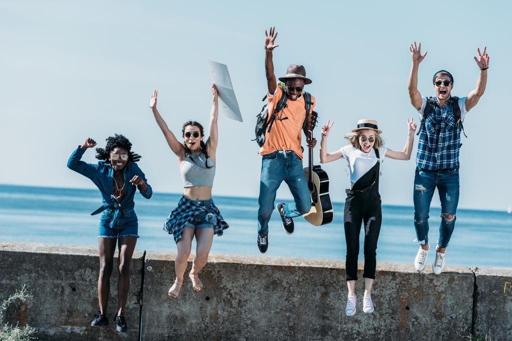 Мультикультурные друзья прыгают с парапета
 - Фото, изображение