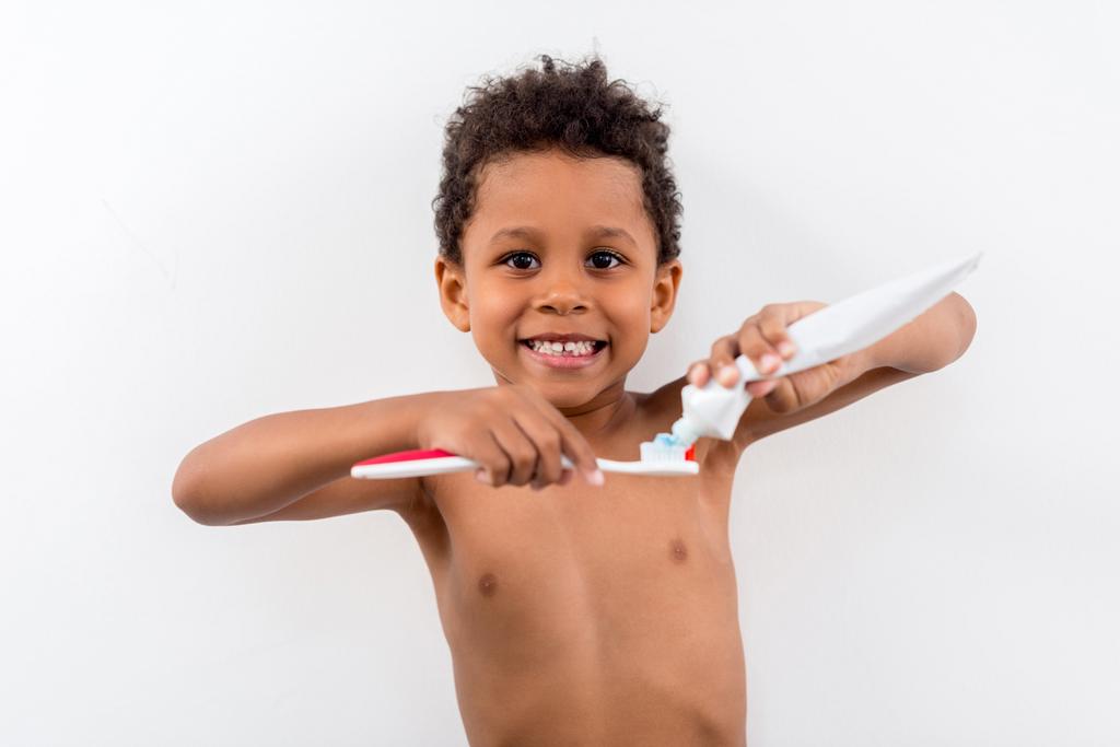 bambino che applica la pasta dentaria sul pennello
 - Foto, immagini