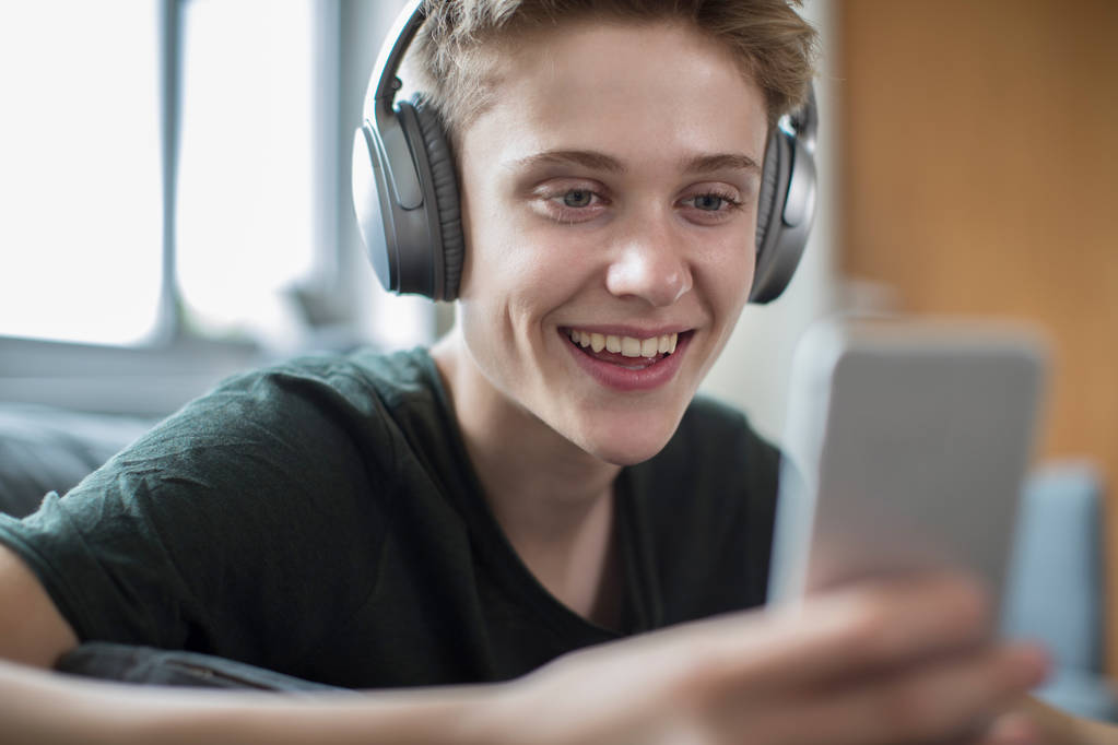 Teenage Boy Streaming Music From Mobile Phone To Wireless Headph - Photo, Image