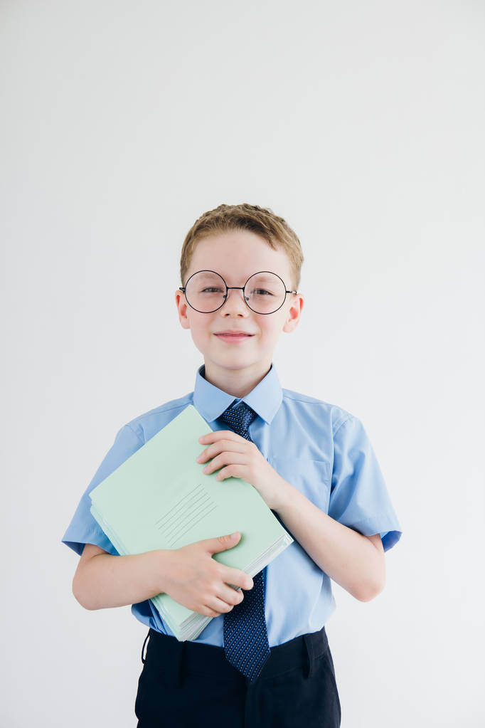 Školák ve školní uniformě a brýle, držící hromadu poznámky - Fotografie, Obrázek