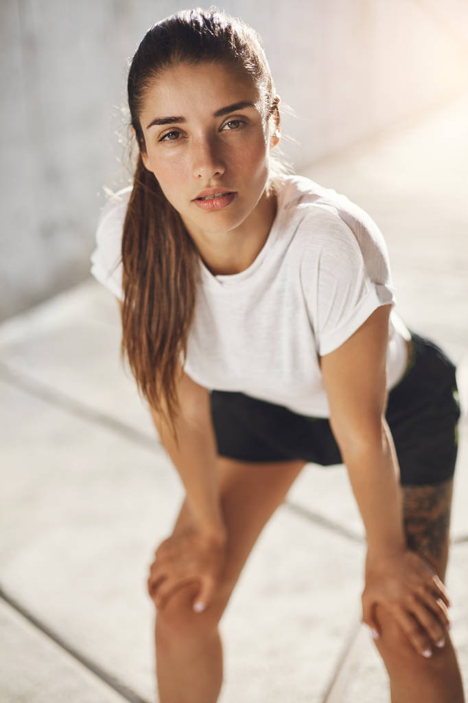 Portrait of female runner after a morning workout. Urban sport concept. - Photo, Image