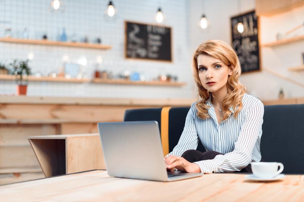 бізнес-леді використовує ноутбук у кафе
 - Фото, зображення