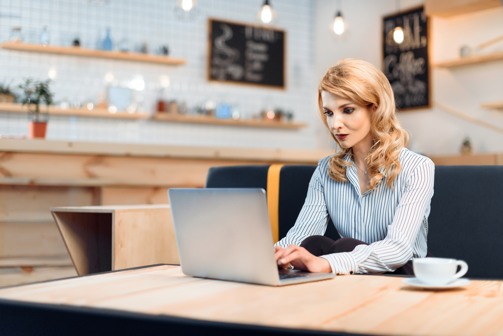 Деловая женщина с ноутбуком в кафе
 - Фото, изображение