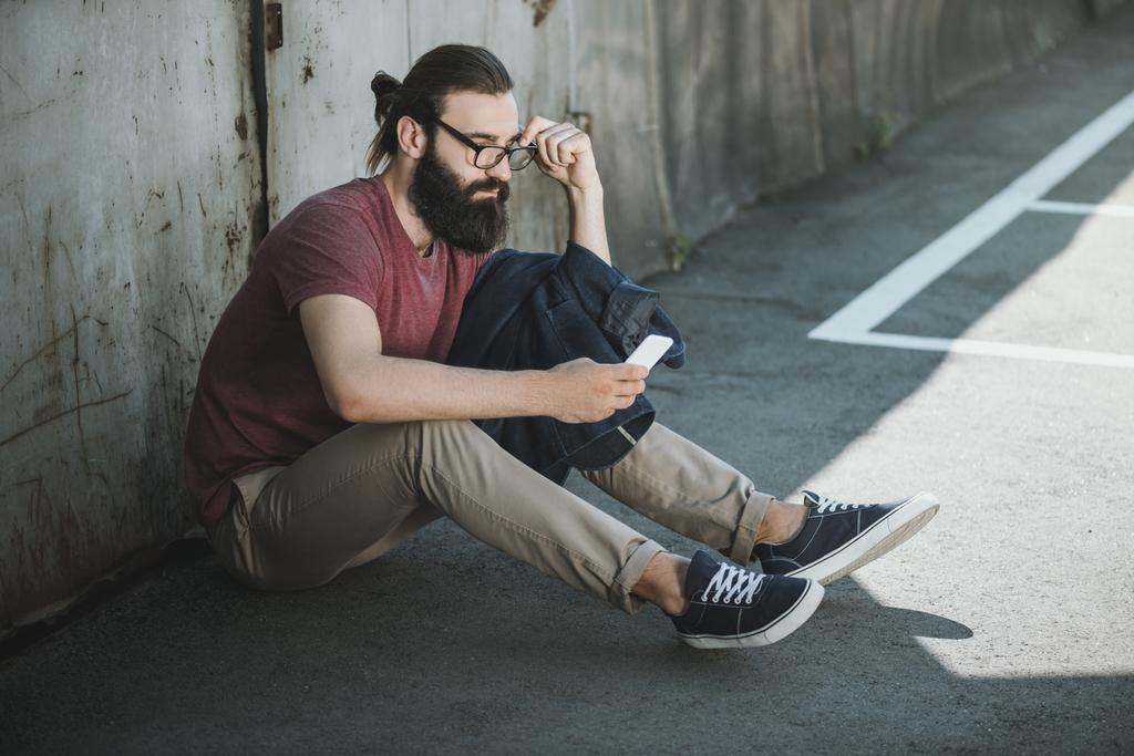 man sitting on floor and using phone - Photo, Image