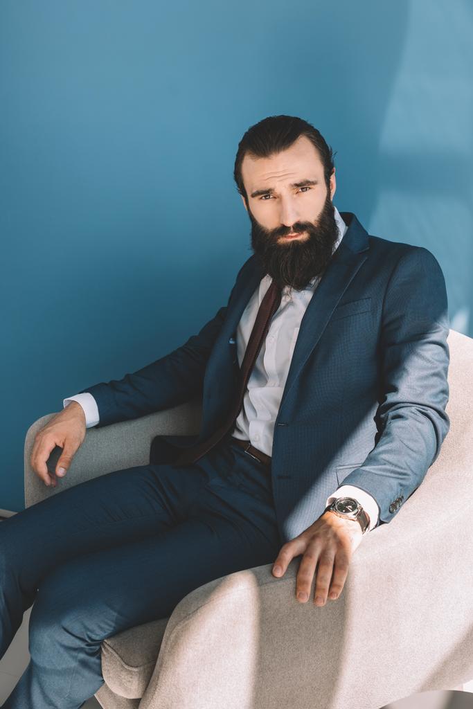 бородатый бизнесмен сидит в кресле
 - Фото, изображение