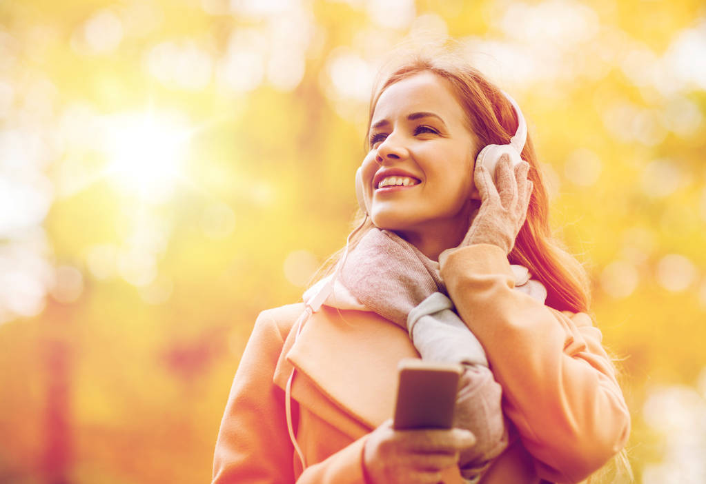 Kobieta z smartphone i słuchawki w jesienny park - Zdjęcie, obraz