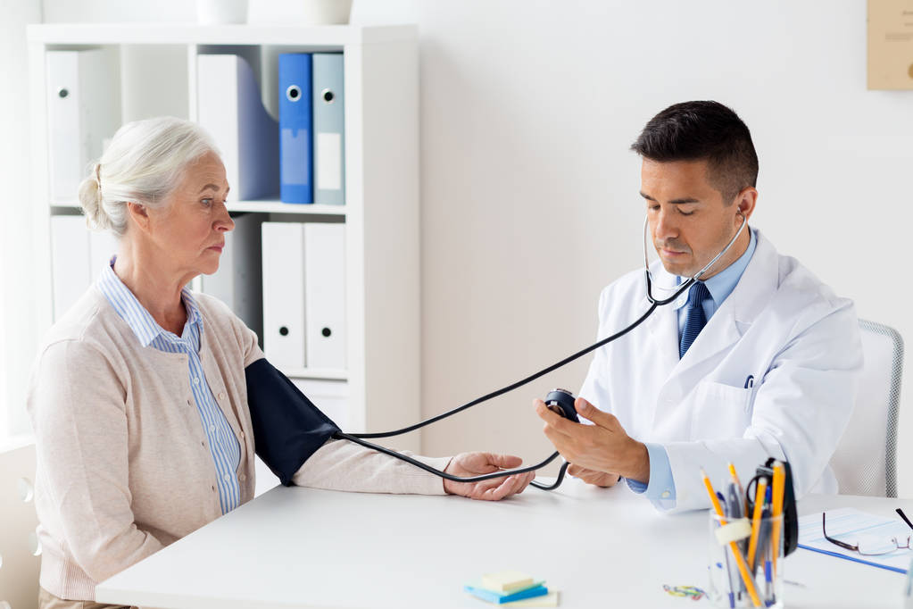 donna anziana e medico con tonometro in ospedale
 - Foto, immagini