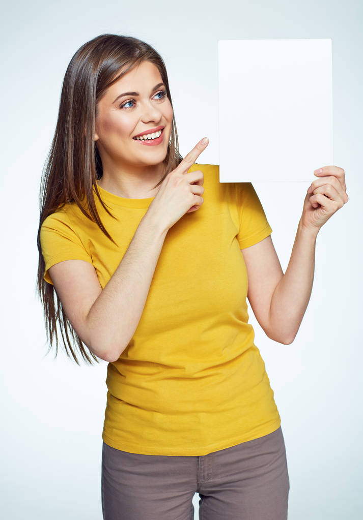 Mosolygó nő sárga inget poining a fehér cégtábla. - Fotó, kép