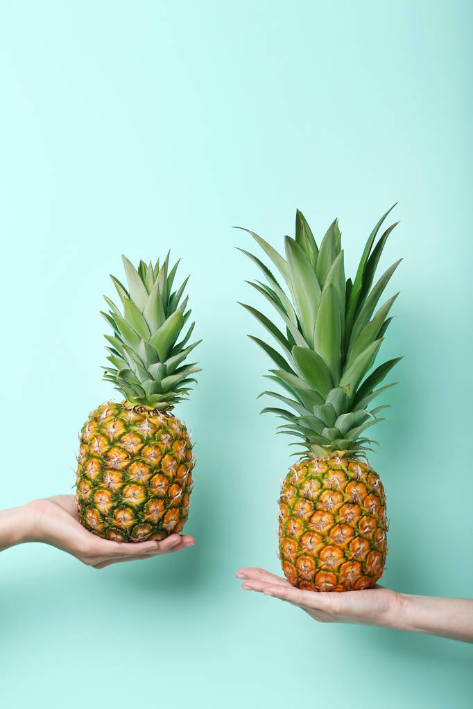 Női kezek gazdaság érett ananász  - Fotó, kép