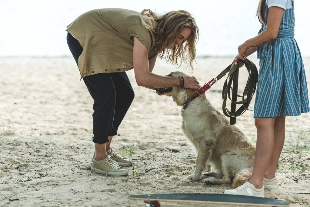 Pari koiran kanssa rannalla
 - Valokuva, kuva