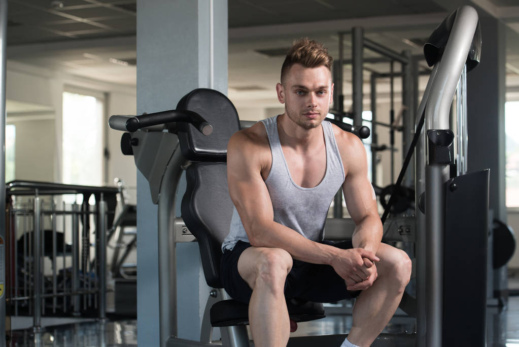 Homem muscular após o exercício descansando no ginásio
 - Foto, Imagem