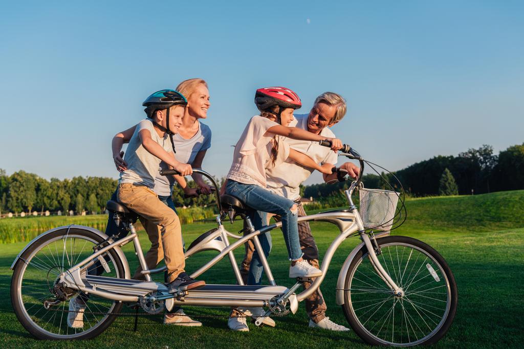abuelos ayudando a los niños a montar en bicicleta
 - Foto, Imagen