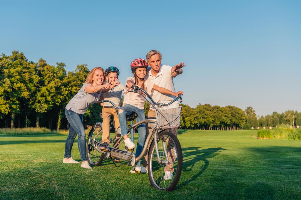 isovanhemmat auttavat lapsia polkupyörällä
 - Valokuva, kuva