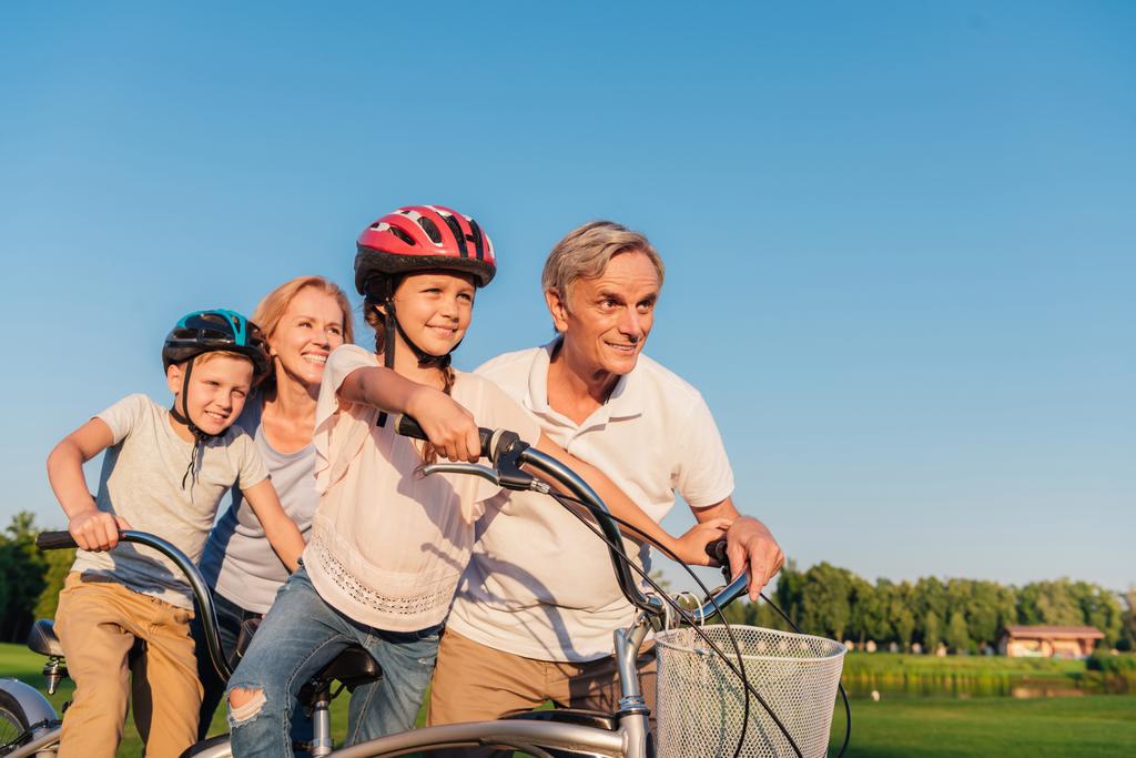 自転車に乗る子どもたちを助ける祖父母 - 写真・画像