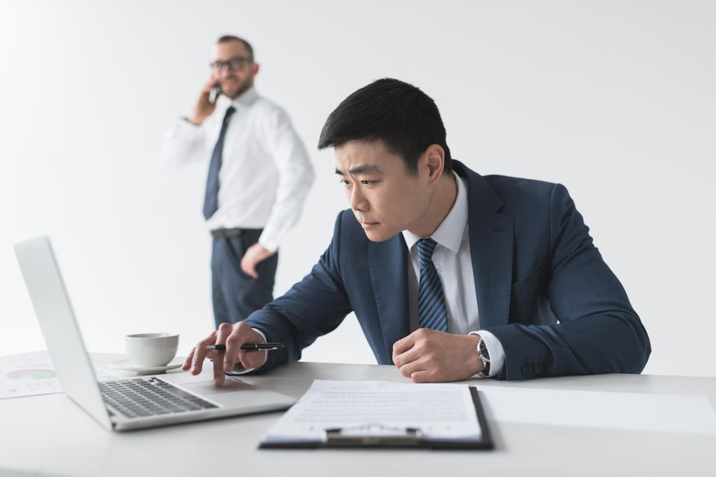 Aziatische zakenman met laptop op werkplek - Foto, afbeelding