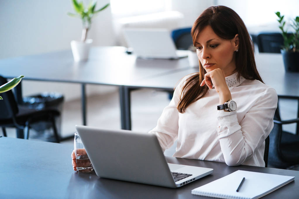 Vrouw op kantoor werkt met laptop - Foto, afbeelding