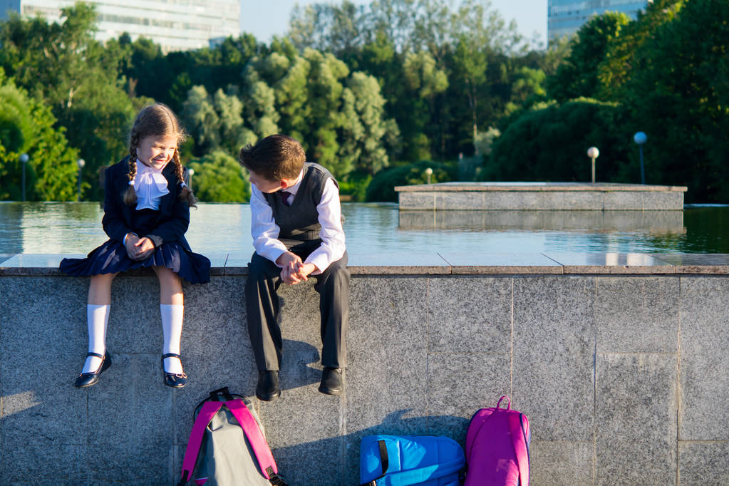 Ragazzo e ragazza sono seduti insieme nel parco dopo la scuola, parlano
 - Foto, immagini