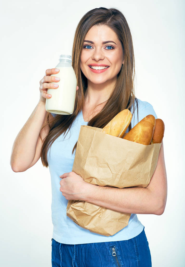 Mujer sonriente de pie sobre fondo blanco con pan y m
 - Foto, Imagen