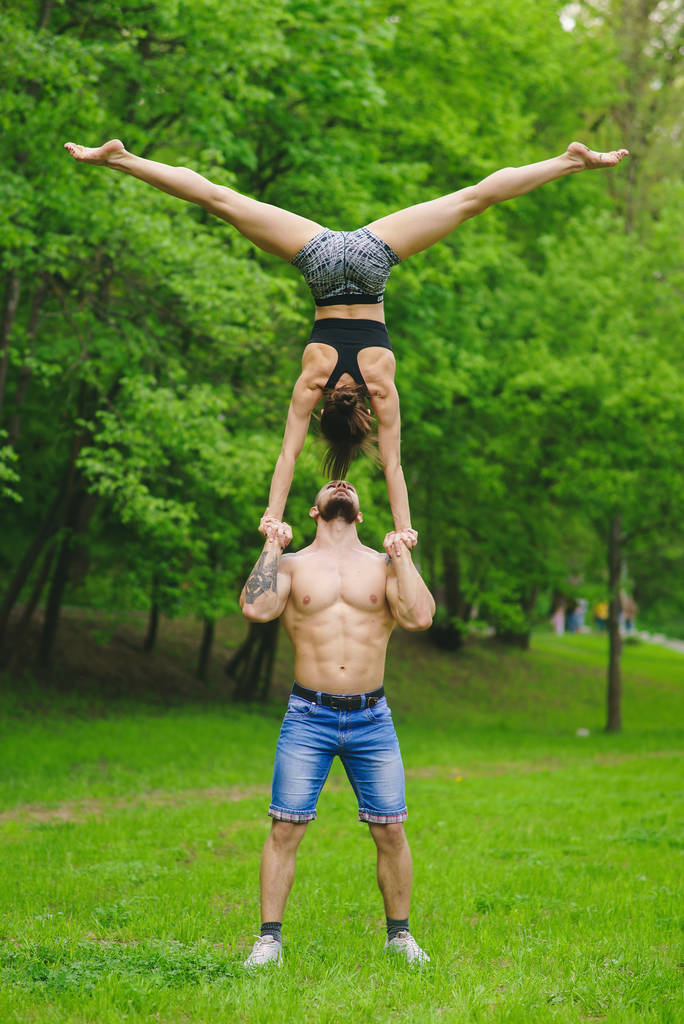 Een man met een meisje houdt zich bezig met atletiek in het park - Foto, afbeelding