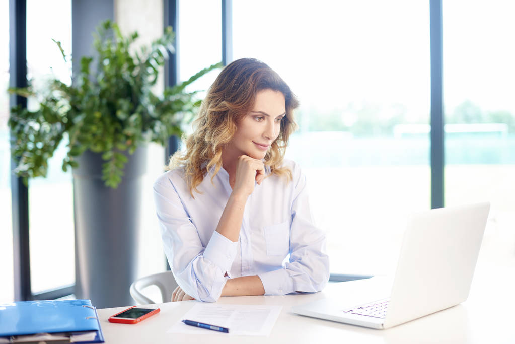  Geschäftsfrau sitzt vor Laptop - Foto, Bild