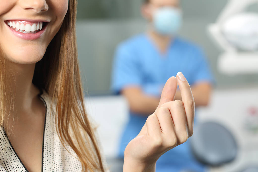 Οδοντίατρος ασθενή χέρι κρατά ένα κενό προϊόν - Φωτογραφία, εικόνα