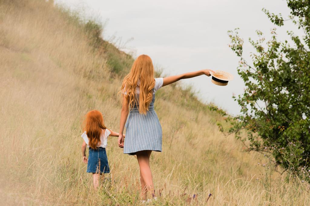 мать и дочь ходят по траве
 - Фото, изображение