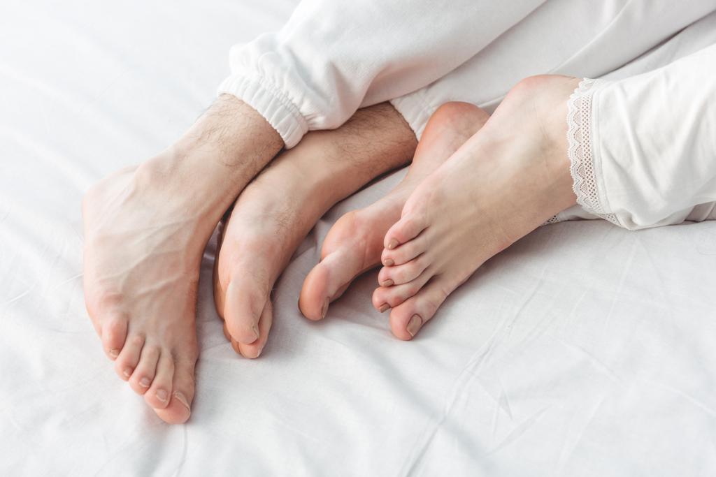 pés de casal deitado na cama
 - Foto, Imagem